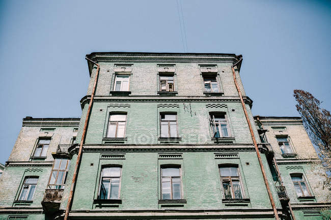 Зовнішній вигляд старого зеленого фасаду будівлі над блакитним небом — стокове фото