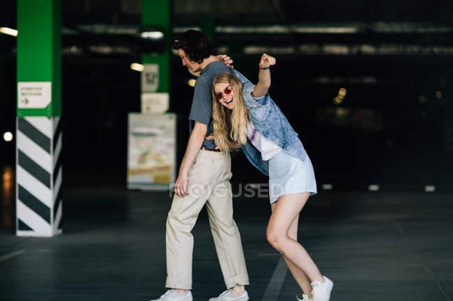 Cheerful couple having fun at parking — Stock Photo