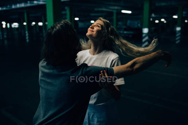Young couple cheerfully bonding at parking — Stock Photo
