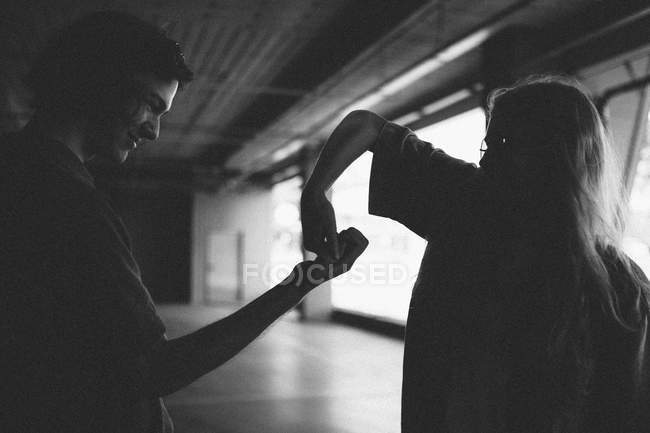 Silhouettes of couple dancing at parking — Stock Photo