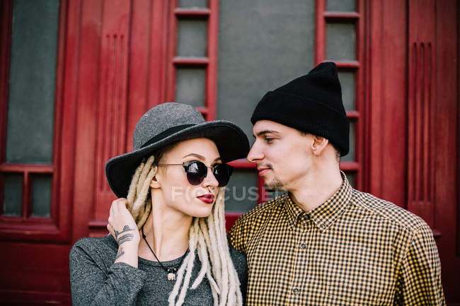Sinnlich stilvolles Paar posiert über roter Tür — Stockfoto