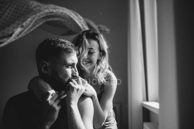 Portrait of young adult couple in bedroom interior, black and white — Stock Photo