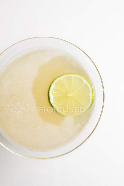 Close-up view of glass with fresh cold summer cocktail and slice of lime — Stock Photo
