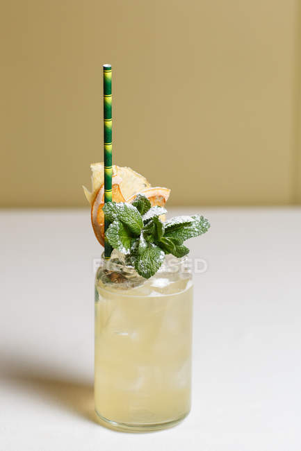 Vue rapprochée du verre avec cocktail d'été frais et froid décoré de feuilles de menthe et de paille — Photo de stock