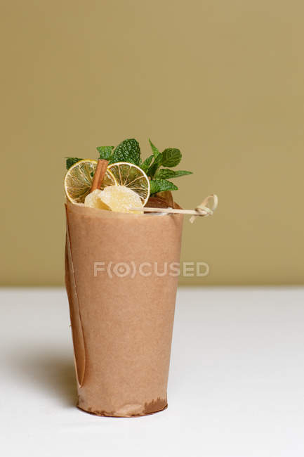 Крупный план свежего коктейля с мятными листьями, сушеными ломтиками лимона и конфетками — стоковое фото