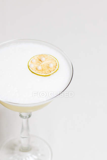 Visão de close-up de coquetel com espuma e fatia seca de limão — Fotografia de Stock