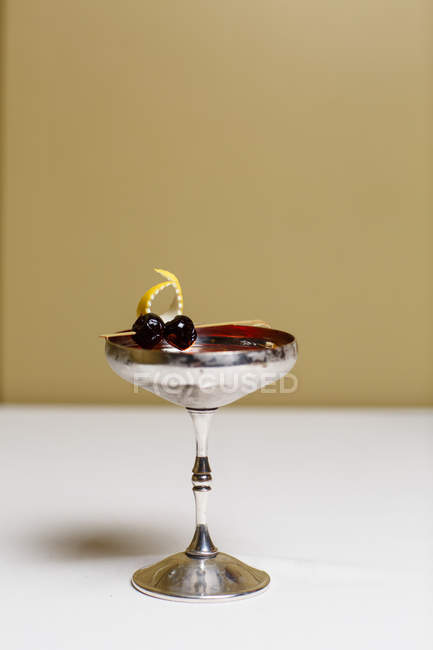 Крупный план коктейля в металлическом стекле с отделкой из ягод — стоковое фото