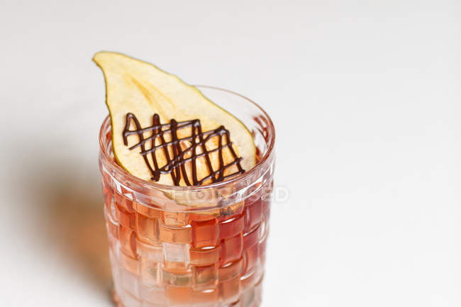 Vista aerea dell'alcool cocktail estivo decorato con fetta essiccata di pera su sfondo bianco — Foto stock