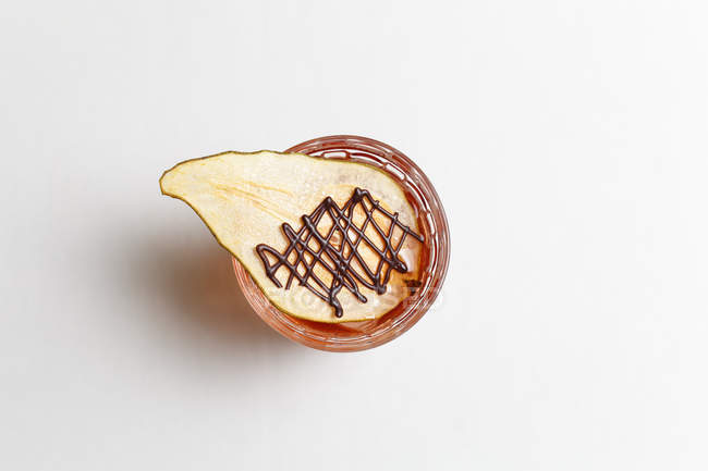 Top view of alcohol summer cocktail decorated with dried slice of pear on white background — Stock Photo