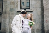 Newlywed couple embracing and posing on city street — Stock Photo