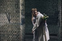 Urbane Szene von frisch vermählten Paaren, die sich vor einer Mauer am Rande des Abgrunds umarmen — Stockfoto