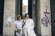 Coppia di sposi a piedi sulla strada della città — Foto stock