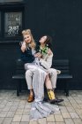 Новоспечена жінка сидить на колінах нареченого на міській лавці — стокове фото