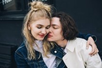 Giovane uomo appoggiato a baciare donna bionda — Foto stock