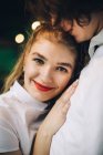 Portrait of young woman leaning on male chest and looking in camera — Stock Photo