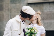 Recién casada pareja besándose en ciudad calle - foto de stock