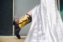 Обрізаний вигляд жіночої ноги з довгою срібною спідницею і черевиком — стокове фото