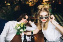 Jeune couple en lunettes de soleil posant à l'intérieur du bar — Photo de stock