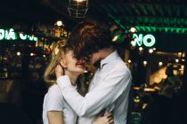 Jeune couple élégant embrasser dans l'intérieur du bar — Photo de stock