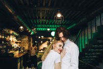 Молодая женщина опирается на грудь парня в интерьере бара — стоковое фото