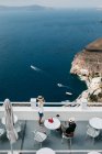 Vista panoramica dell'hotel nel maestoso Santorini con viaggiatori rilassanti, Egeo meridionale, Thira, Santorini, Grecia — Foto stock