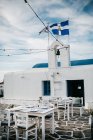 Vista panorámica de la cafetería de la calle con campana y cruz de la iglesia, Paros, mar Egeo, Cícladas, Grecia - foto de stock