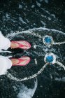 Abgeschnittenes Bild weiblicher Füße am schwarzen Strand mit Hasenbild — Stockfoto