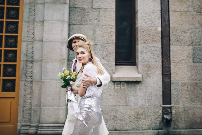 Pareja recién casada caminando por la calle de la ciudad - foto de stock