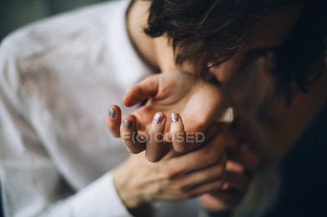 Young man holding and kissing female wrist — Stock Photo