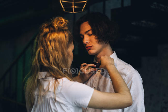 Jovem mulher ajustando laço laço no namorado — Fotografia de Stock