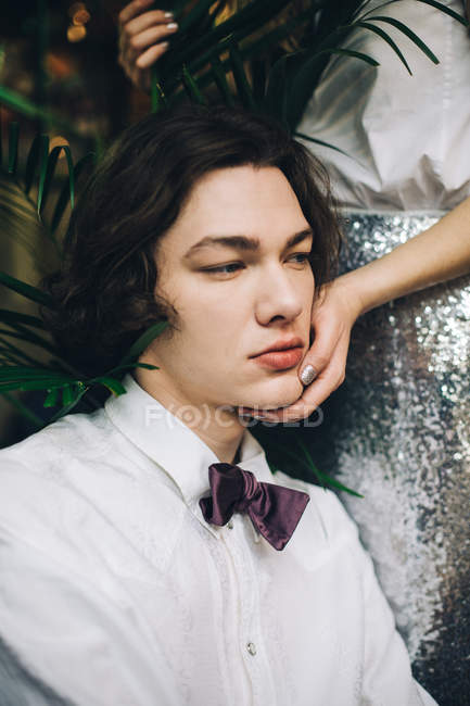 Young man leaning on girlfriend hand in silver skirt — Stock Photo