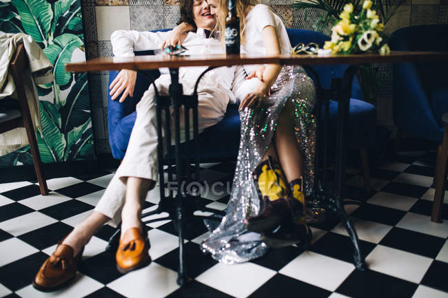 Fashionable newlywed couple embracing in cafe interior — Stock Photo