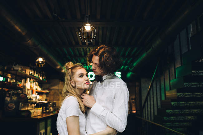 Young stylish hugging in bar interior — Stock Photo
