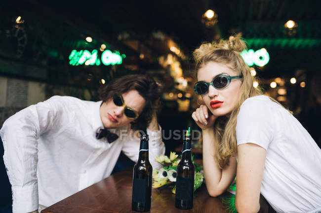Young couple in sunglasses posing in bar interior — Stock Photo