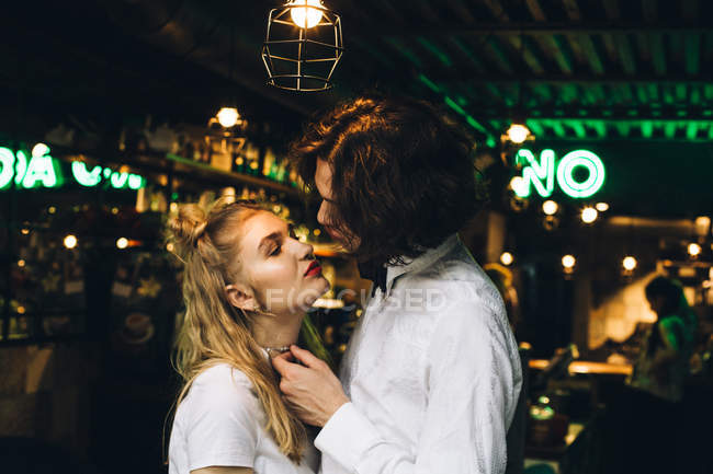 Giovane coppia elegante appoggiata a baciare al bar interno — Foto stock