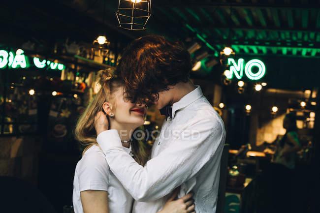 Jovem casal elegante beijando no bar interior — Fotografia de Stock