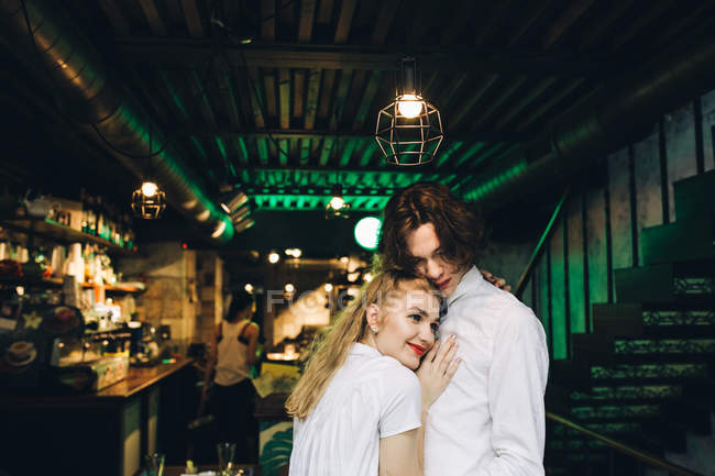 Giovane donna appoggiata sul petto fidanzato in bar interno — Foto stock