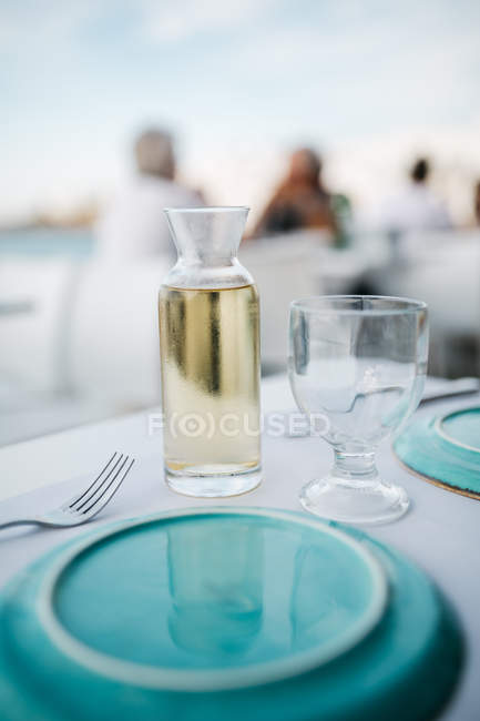 Closeup view of white wine with glass on table at restaurant — Stock Photo