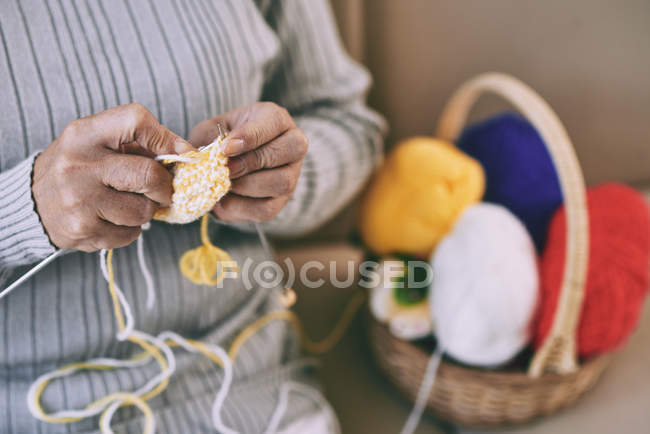 Жінка насолоджується в'язанням вдома — стокове фото
