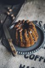 Шоколадний торт з заскленими пеканчиками на тарілці з ножем — стокове фото