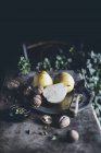 Свежие целые и наполовину груши с грецкими орехами на тарелке с ножом — стоковое фото
