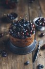 Chocolate cake with summer berries on rustic wooden table — Stock Photo