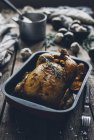 Whole roasted chicken with orange and rosemary in baking dish — Stock Photo