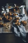 Petits pains maison à la cannelle sur table rustique en bois — Photo de stock