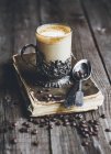 Café branco em vidro retro no livro com grãos de café — Fotografia de Stock