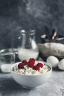 Russian cottage cheese in bowl with fresh raspberries — Stock Photo
