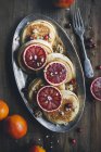 Pancakes with bloody orange slices on metal platter — Stock Photo