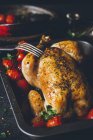 Pollo arrosto intero con pomodori in teglia — Foto stock