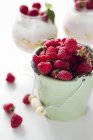 Small bucket of fresh raspberries on white surface — Stock Photo