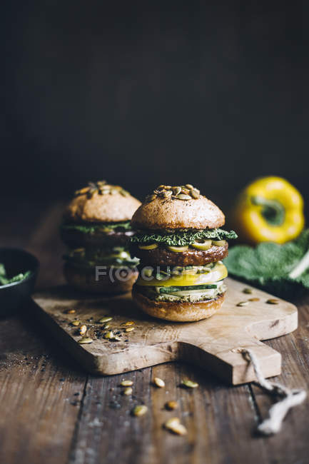 Homemade green pesto beef burgers on wooden board — Stock Photo